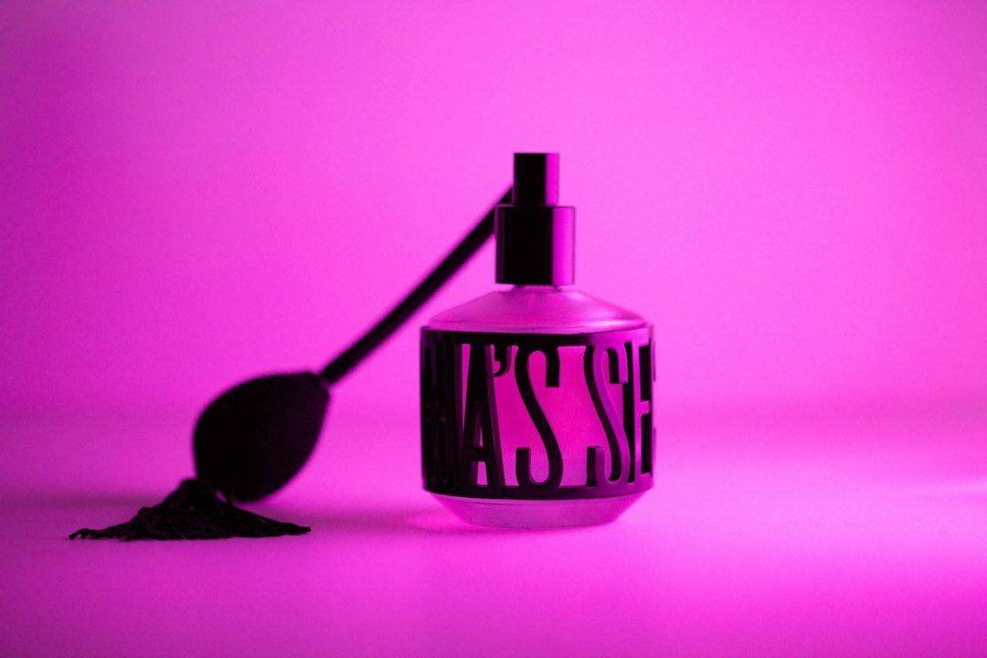 a bottle with a spoon next to it on a pink background (photographie d’illustration)