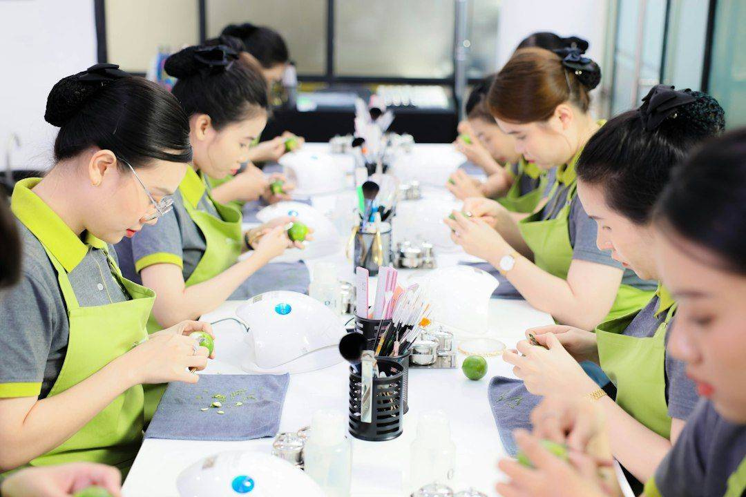 a group of women sitting at a long table (photographie d’illustration)