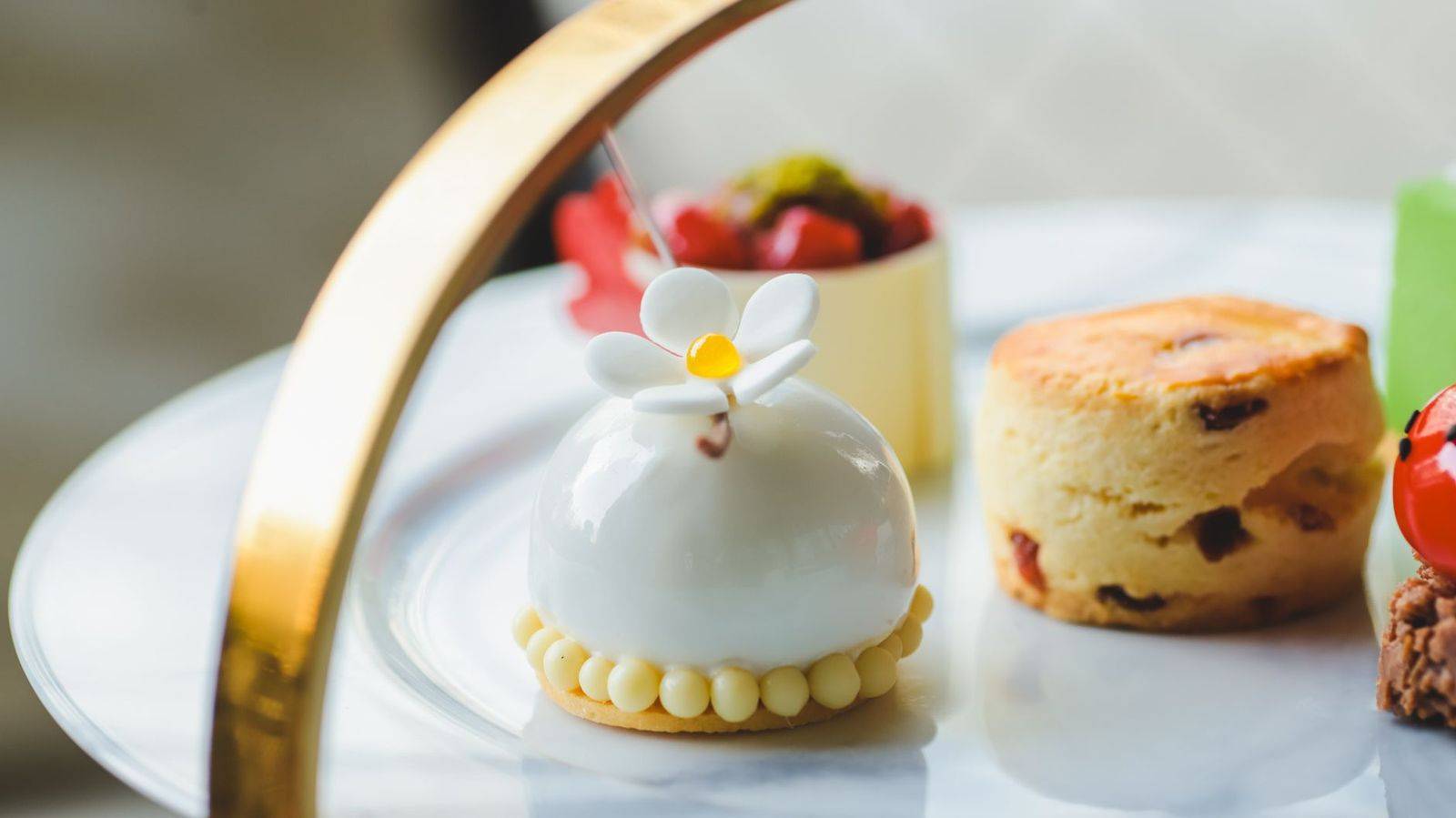 Sophisticated dessert arrangement featuring a floral-topped confection on a marble plate. (photographie d’illustration)