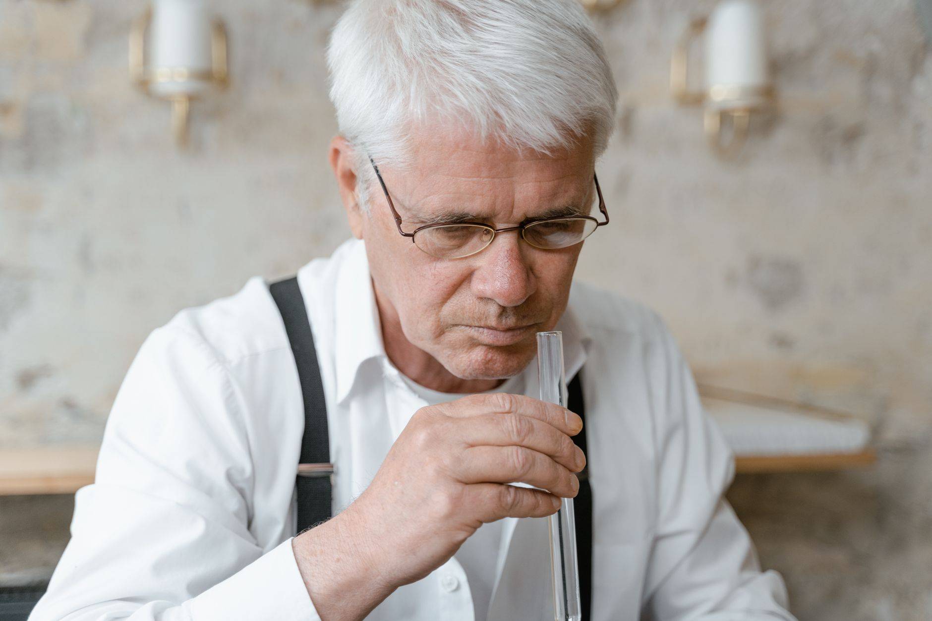 Elderly man analyzing scent from a test tube, focused on fragrance. (photographie d’illustration)